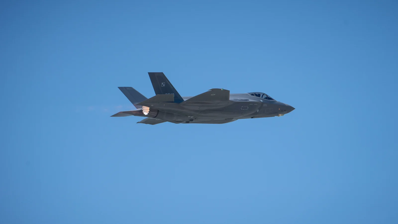 Polski F-35A Husarz w locie na tle błękitnego nieba.
