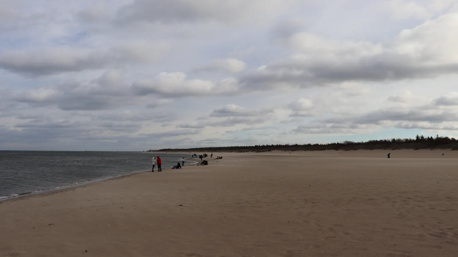 Plaża Gdańsk Stogi z szerokim pasem piasku i spokojnym brzegiem morza.