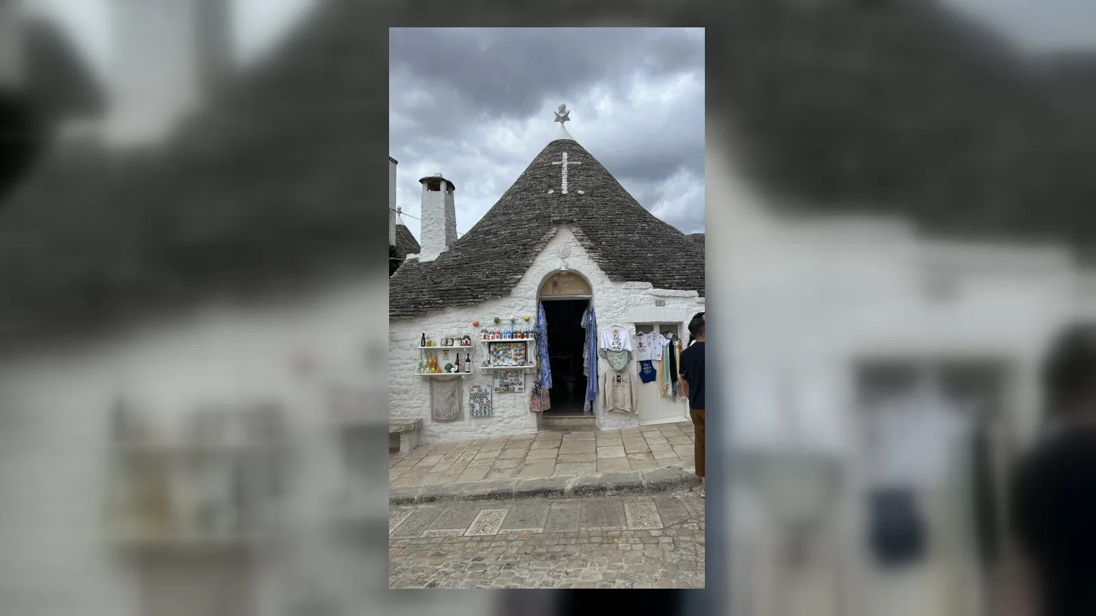 Biały trullo ze stożkowym kamiennym dachem w Alberobello.